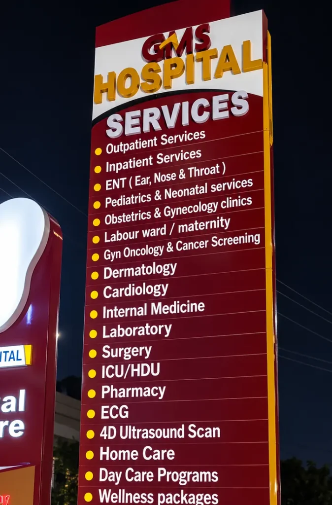 Tall directory sign listing hospital services, lit at night